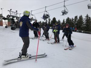 Group of people at a ski training session receiving direction from an instructor at Snow Valley’s Masters Racing Program in Edmonton.