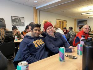 Man and woman smiling and enjoying beers indoors after a race at Snow Valley’s Masters Racing Program in Edmonton.