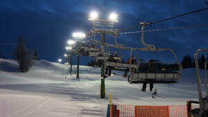 A chairlift carrying guests up a snow-covered hill at night at Snow Valley in Edmonton during a winter holiday event.